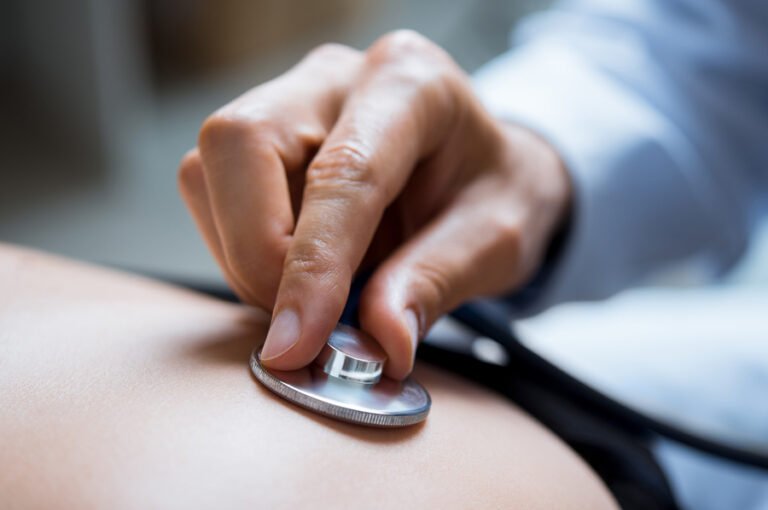 Doctor using a stethoscope on patient