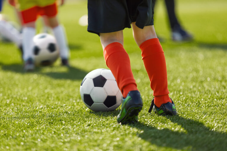 Picture of children kicking soccer balls on a field.