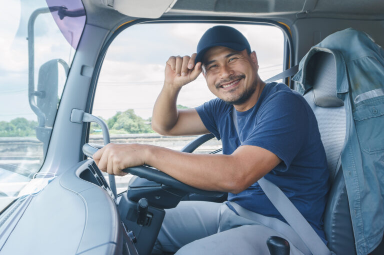 Picture of a commercial driver smiling and sitting in his truck.