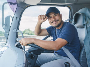 Smiling man in the driver seat of a commercial truck