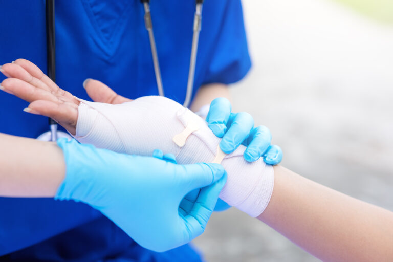 Picture of a doctor applying a compression bandage to a patient's injured wrist.