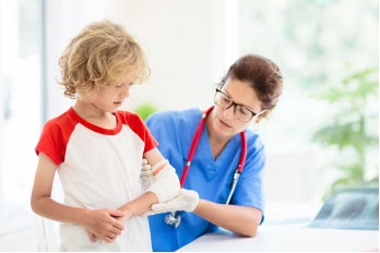 Doctor measuring the child arm during treatment.