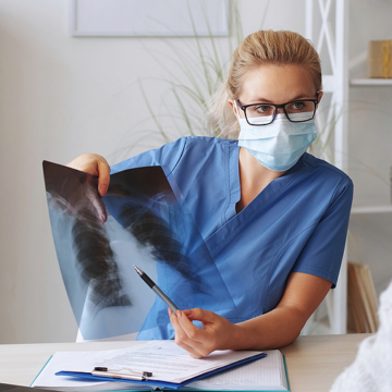 A healthcare worker holds up a chest x-ray