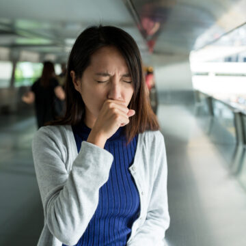 Picture of a woman coughing.