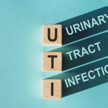 Picture of wooden blocks with the letters U, T, and I on them, with the words Urinary Tract Infection in the shadows.